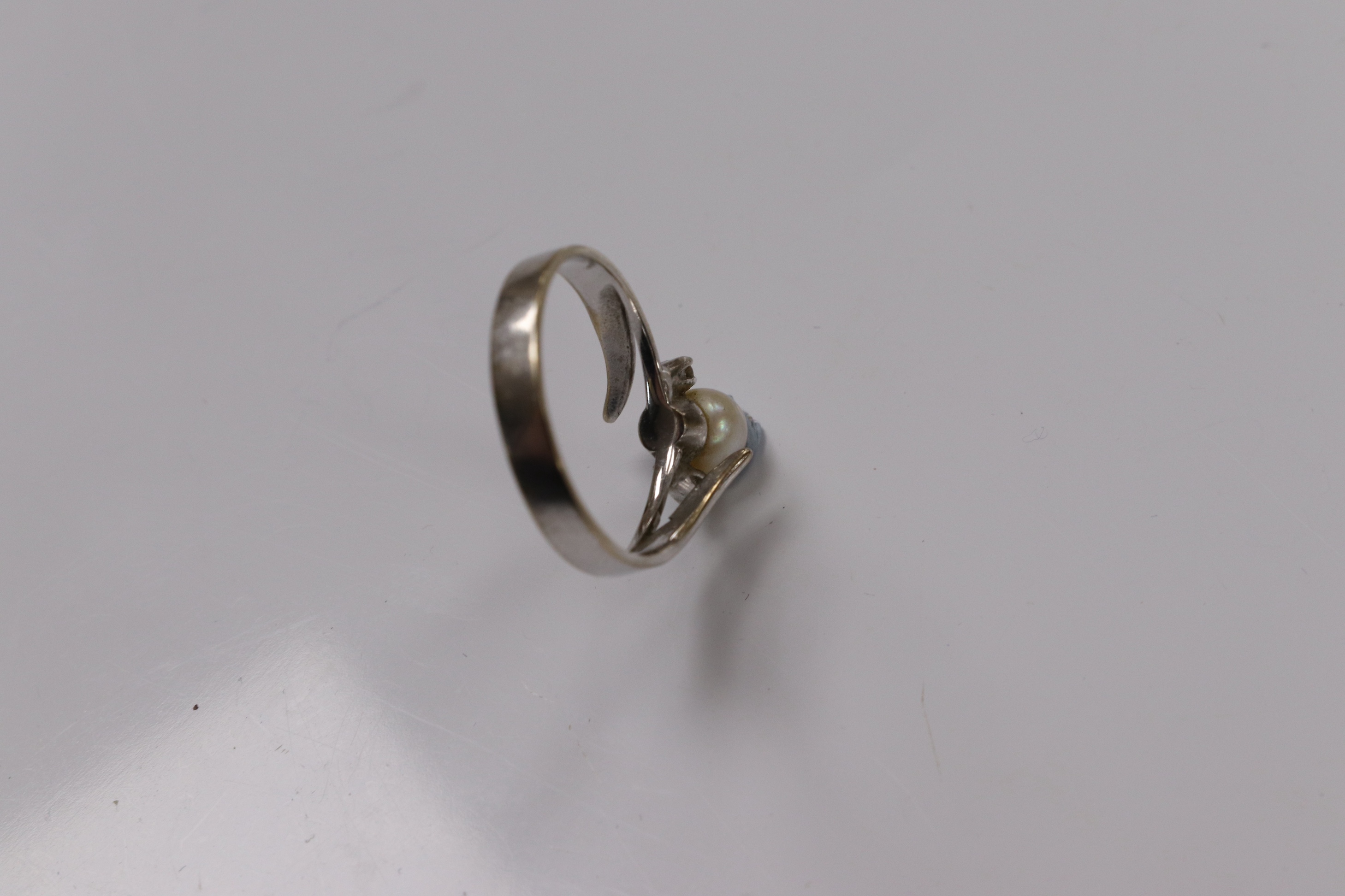 A modern 18ct white gold and single stone cultured pearl set ring, with two stone diamond set shoulders, size Q, gross weight 3.7 grams. Condition - poor to fair